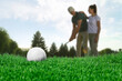 © New Africa - Golf ball and players on course, selective focus