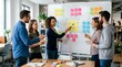 © gabriel - Diverse group of people brainstorming ideas on a whiteboard with colorful sticky notes in office