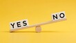 © mcjanuald - Wooden blocks with yes and no words balancing on a seesaw illustrating business decision making