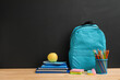 © Pixel-Shot - Back to school education with blue backpack, stack of notebooks, apple, and pencils on wooden desk