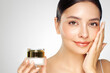 © Oleg Gekman - Beauty woman applying cream on her face. Young woman with clean fresh skin. Model with a jar of face cream