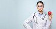 © Oleg Gekman - Portrait of a young female doctor in a lab coat holding a green apple. Diet and healthy eating
