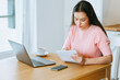 © Oleg Gekman - Beautiful young woman working with laptop computer in home kitchen. Work at home. Freelance, remote work