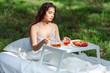 © Oleg Gekman - Woman wakes up in a summer forest. Young woman has breakfast in bed in a summer forest
