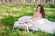 © Oleg Gekman - Woman wakes up in a summer forest. Young woman has breakfast in bed in a summer forest