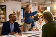 © Rido - Happy businesswoman giving a high five to a colleague during meeting