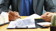 © Siwaporn - Real estate professional reviewing property documents and housing investment reports at office desk. Mortgage planning, real estate analysis, property management, home buying and financial consulting.