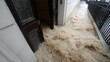 © 锴 张 - Severe flood disaster with flood water and muddy water storm rushing into building through partially open door, showing emergency water damage, damage, destruction, heavy flow, urban flooding crisis.