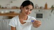 © Yuliia - Happy healthy Hindu Indian pregnant woman at home showing positive pregnancy test smiling looking camera female Arabian girl carefree anticipating childbirth motherhood family health medicine indoor