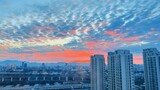 Stunning sunset sky with colorful clouds over modern city skyline, urban architectural landscape background