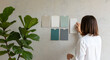 © Mst.China Khatun - Woman choosing paint colors for interior design project with plant