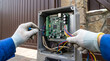 © HADI INCREDIBLE - Technician repairing an electronic automatic gate controller circuit board with a screwdriver