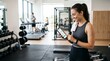 © IBMS  - Mulher em academia usando aplicativo fitness