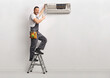 © Ljupco Smokovski - Air conditioner technician on a ladder