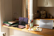 © Alba Vitta Studio/Stocksy - Workspace With Laptop, Notebooks, and Coffee in a Kitchen Area