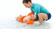 © Rifat22 - Smiling mother teaching her happy toddler boy to float in water with inflatable armbands on isolated white background