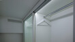 © shine.graphics - Modern white wardrobe interior with sliding glass door and empty hangers