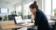 © Lina Grebe - Young business woman analyzing financial data on laptop in modern office
