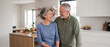 © Xenia - Happy older couple smiling and looking at each other in a modern kitchen. Cheerful senior husband and wife enjoying retirement at home