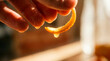 © Rendara Studio - Precise hand holds dripping orange peel in glowing macro citrus study