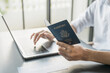 © Charlie's - Hand Man Online booking and buying plane tickets using laptop phone and credit card Planning trip travel vacation with passport and ticket