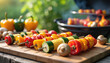© Inna - colorful vegetable skewers prepared on a wooden board with a grill in the background for outdoor cooking and summer barbecues