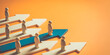 © MDRAJAN - A group of people standing on arrows pointing in different directions on an orange background, symbolizing individuality and diverse paths in business or life