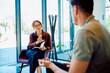 © we.bond.creations - Female professional giving guidance and support to a man during a therapy session in a modern office setup
