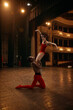 © master1305 - Ballet dancers performing elegant lift on theater stage during rehearsal. Concept of stage partnership, dance school advertising, theater arts training, graceful performance preparation.