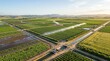 © dira - Aerial view of modern agricultural fields with pivot irrigation watering crops in a vast rural valley during golden hour.