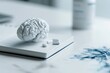 © Evgeniia - Brain model with medication and notebook, representing mental health treatment, neuroscience research, cognitive care and psychiatric healthcare concepts