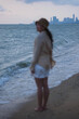 © Farknot Architect - Vertical blurred image of a woman standing alone by the sea with stormy sky