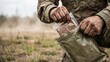 © Katawut - Soldier Opening Military Meal Pouch with Hands in Field Ready to Eat Food