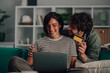 © Zamrznuti tonovi - Happy couple shopping online with laptop and credit card, enjoying secure e commerce and digital payment at home