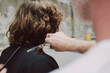 © Luciano Spinelli/Stocksy - Close up hairdresser Cut Curly Hair