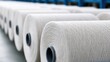 © Akash - Industrial yarn bobbins on spools in textile factory