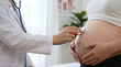 © DebbyMelindaYanti - Doctor using a stethoscope to perform a prenatal check-up on a pregnant woman's belly. Healthcare and motherhood concept
