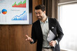 © Zoran Jesic - Business speaker presenting financial growth data during a corporate meeting