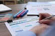 © New Africa - Woman with monthly planner at wooden desk, closeup