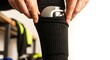 © Lucas - Closeup of a soccer player putting on a shin guard inside a black sock before a match in a locker room