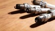 © Nami Liu - Close-up of used spark plugs on wooden background for auto repair, mechanical parts and engine maintenance design
