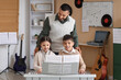 © Pixel-Shot - Happy young children learning piano with male teacher, music education and skill development for kids, a male teacher guides a young boy and girl as they learn to play the piano