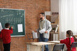 © Pixel-Shot - Music teacher guiding young student in classroom, learning musical staff and notes on chalkboard, educational development and the acquisition of new skills in a supportive learning environment