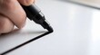 © KinanZ - Close up of hand drawing thick black line with marker