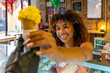 © unai - Happy woman receiving yellow ice cream cone in shop
