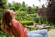 © Westend61 - Smiling woman with eyes closed relaxing while sitting on chair in garden