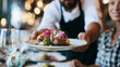 © Marvel’s Nook - Professional waiter serving a gourmet meal to restaurant guests, highlighting hospitality, fine dining, excellent service, customer experience, fresh cuisine and elegant dining atmosphere