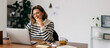© (JLco) Julia Amaral - Middle-aged woman working remotely in cozy home office setting