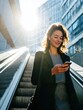 © valeo5 - Happy smiling business woman checking smartphone on city escalator path outdoor while commuting back to home office with bright sun flare and modern corporate building architecture background