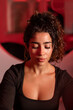 © Rodrigo - Sweaty Latina athlete recovering after workout under photobiomodulation red light therapy in wellness and fitness environment